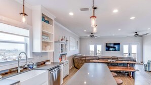 Una cocina moderna con una isla central, estanterías empotradas y un comedor con banco.