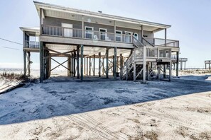 A beachfront house with a balcony, a staircase, and a number '2429' on the front. - Charming beachfront home with Gulf views & wraparound deck - right on the sand (Dauphin Island)