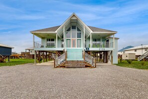 A two-story beachfront house with a balcony, a covered entryway, and a number 2126 sign. - Two-story, dog-friendly home with partial ocean views, decks, private washer,dryer (Dauphin Island)