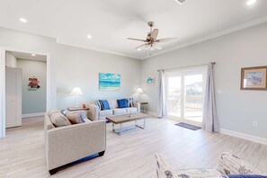 A spacious living room with a sofa, coffee table, and a ceiling fan. - Dog-friendly home with Gulf views, washer,dryer & central AC (Dauphin Island)