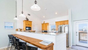 Una cocina con isla central, armarios de madera e iluminación colgante.