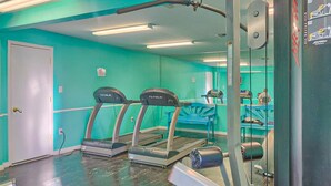 A gym with treadmills, a weight bench, and a mirrored wall. - Coastal condo with water views, shared pool, and tennis court (Orange Beach)