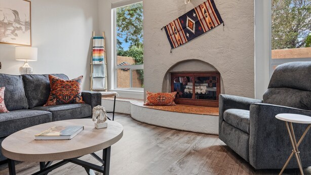Una sala de estar con chimenea, un sofá, una mesa de centro y una estantería.