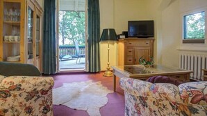 A living room with a sofa, a glass coffee table, a television, and a cabinet. - Strandvilla Hubertus - H2 - Frida Kahlo (Ostseebad Boltenhagen)