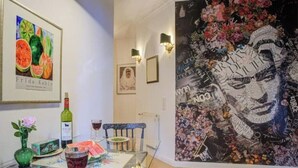A dining area with a glass table, wine glasses, and a framed artwork on the wall. - Strandvilla Hubertus - H2 - Frida Kahlo (Ostseebad Boltenhagen)
