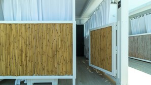 A corridor with white walls and bamboo partitions, leading to a room with a bed and a window. - Residence Rossini Suites & Poll (Alliste)