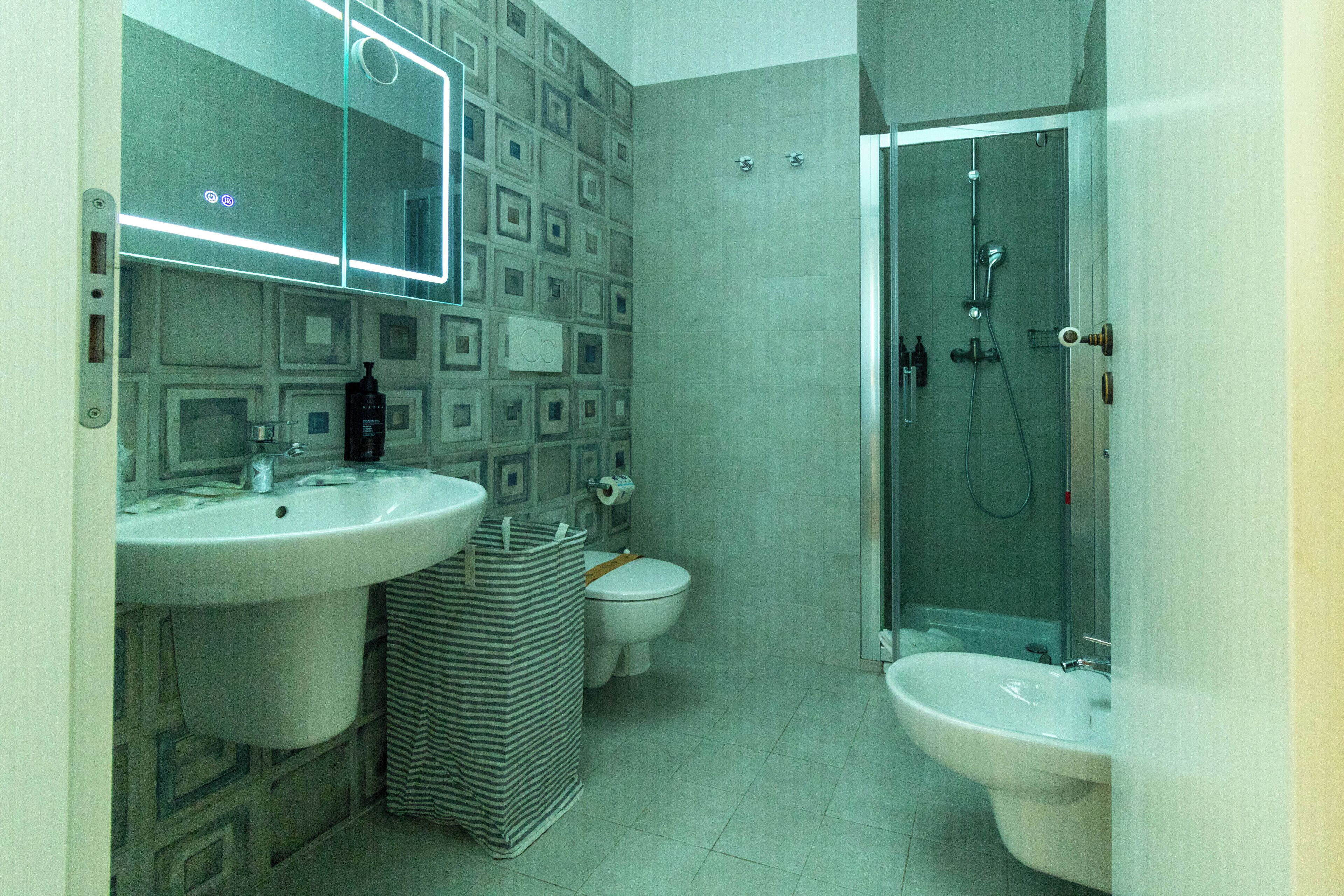 Ein Badezimmer mit Waschbecken, Toilette, Bidet und Dusche.