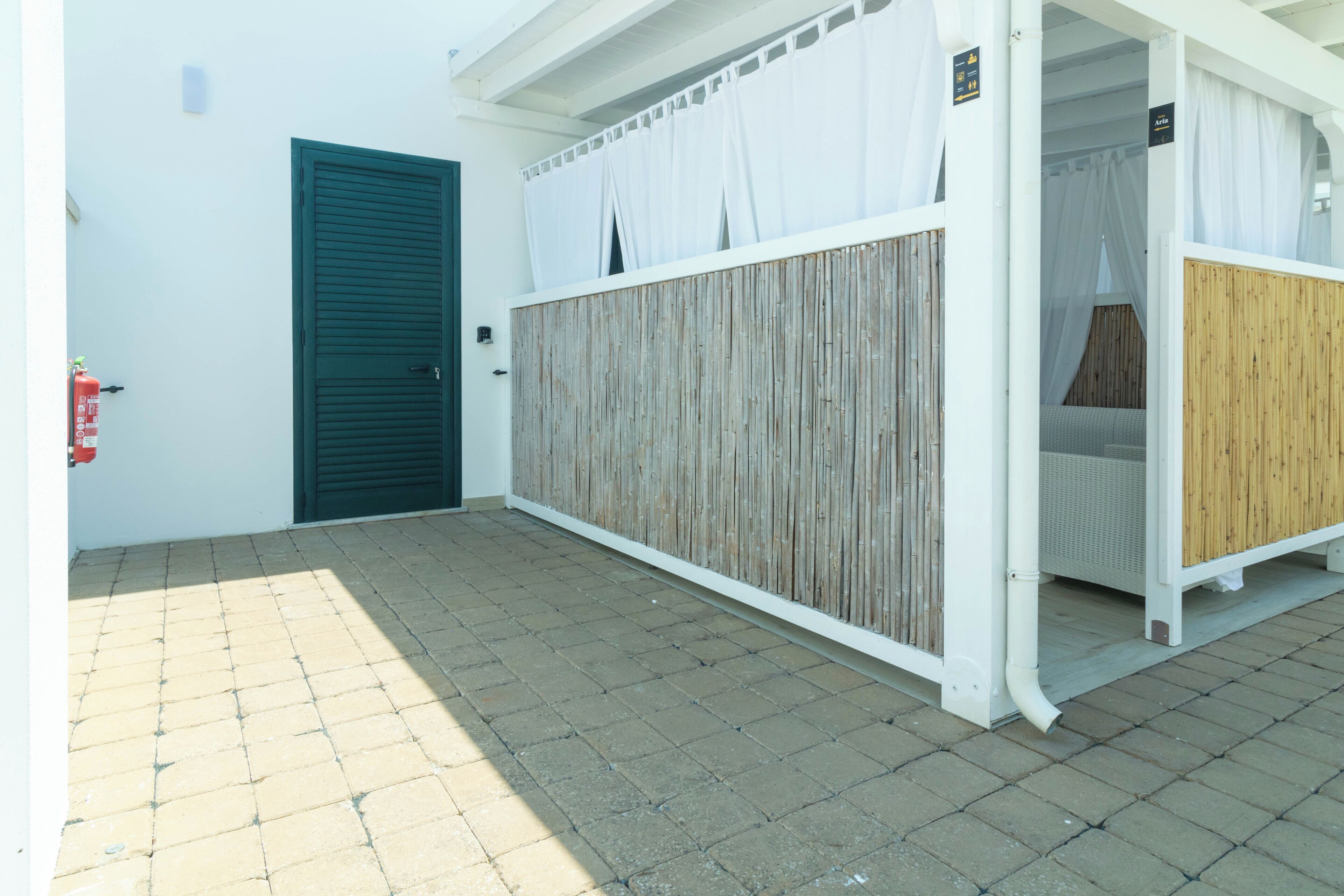 A building with a green door, a white wall, and a wooden partition.