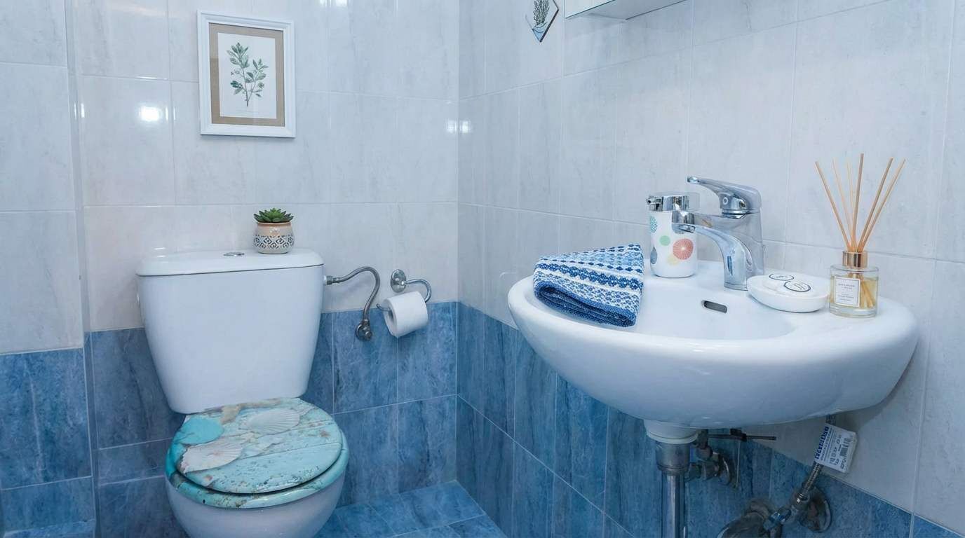 Ein Badezimmer mit Toilette, Waschbecken und einem gerahmten Bild an der Wand.