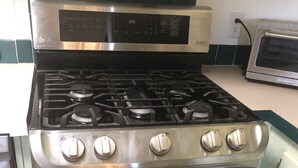 A kitchen with a stainless steel stove, oven, and microwave. - Eagle's Nest- A Tranquil 3-bedroom home with amazing views in charming Espanola (Espanola)