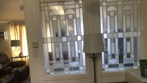 A room with a wooden table, a lamp, and a window with decorative glass panes. - Eagle's Nest- A Tranquil 3-bedroom home with amazing views in charming Espanola (Espanola)