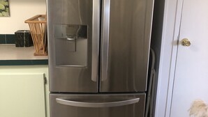 A stainless steel refrigerator in a kitchen with a white cabinet and a tiled floor. - Eagle's Nest- A Tranquil 3-bedroom home with amazing views in charming Espanola (Espanola)