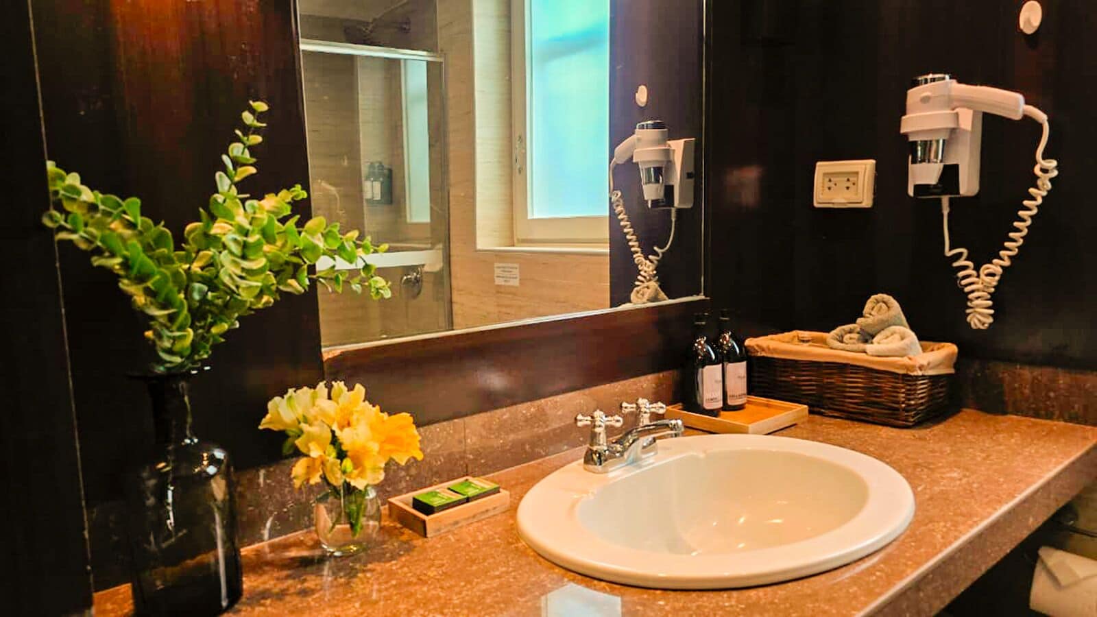 A bathroom with a sink, mirror, and toiletries.