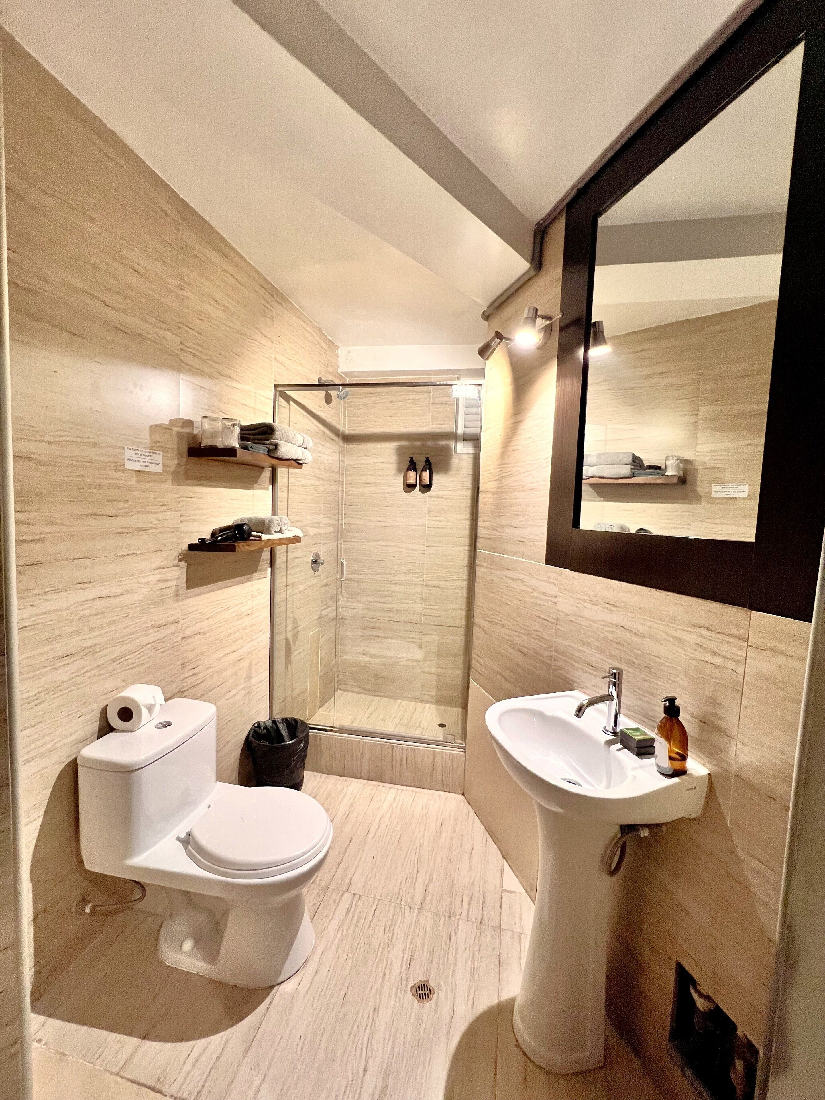 A modern bathroom with a toilet, sink, and shower area.