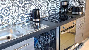 Une cuisine moderne équipée d’un lave-vaisselle, d’un four et d’une machine à café.