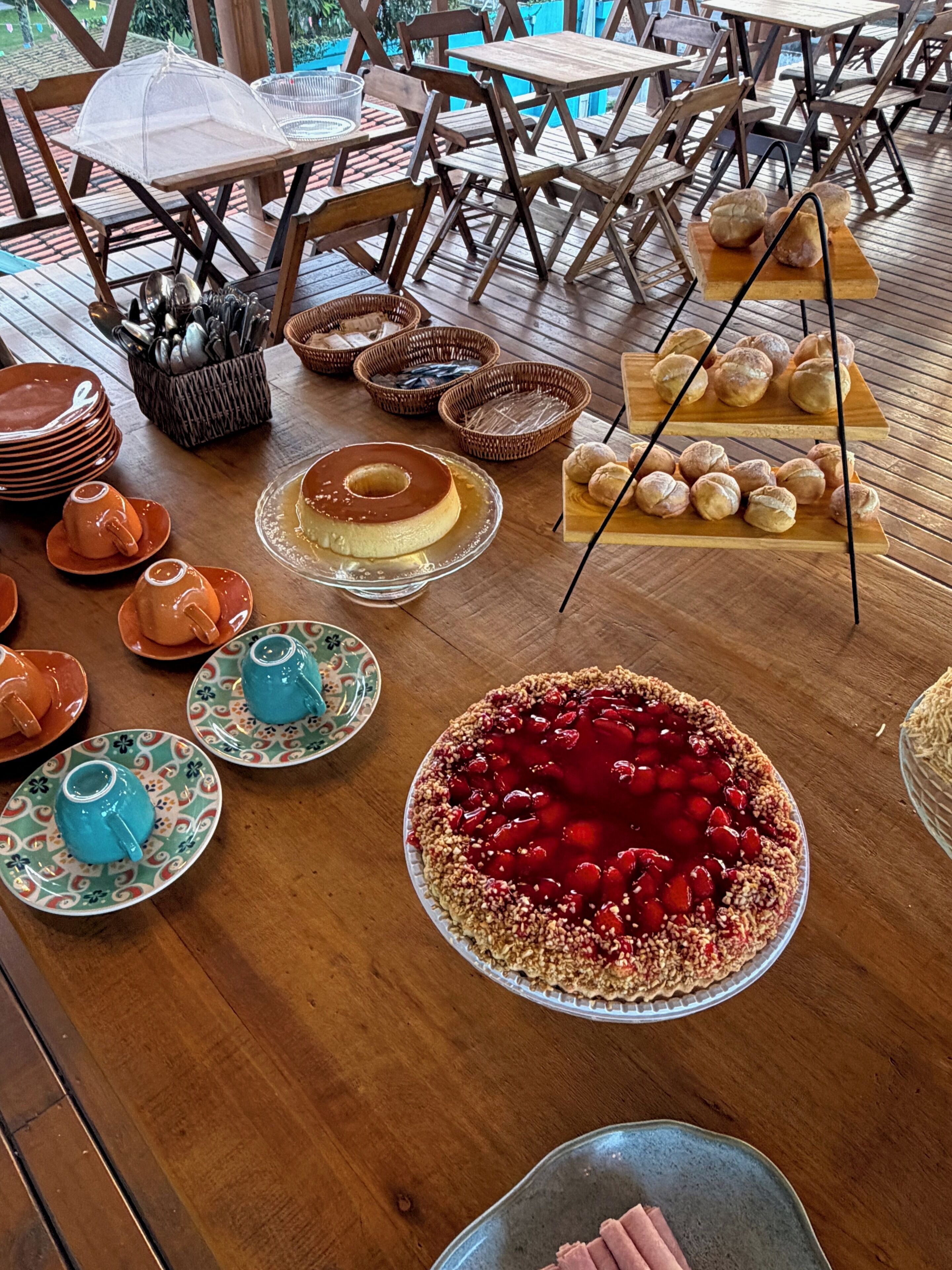 A wooden table with various food items, including a pie, bread, and teapots.