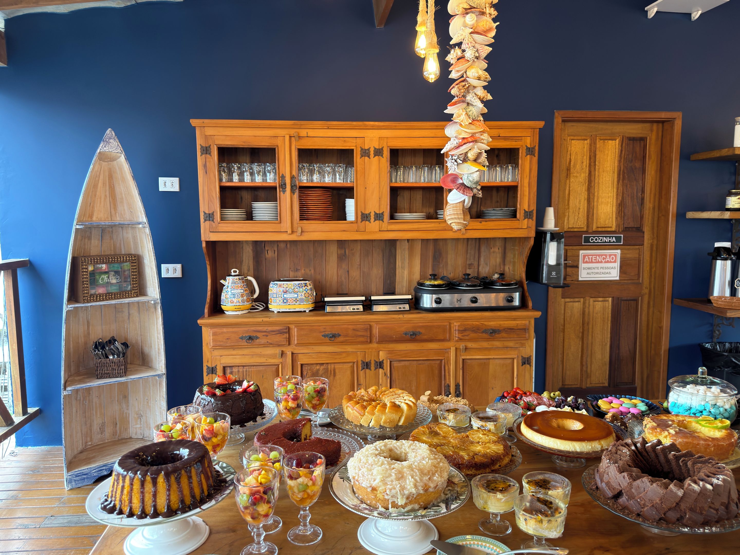A kitchen with wooden cabinets, a stove, and a variety of desserts on the counter.