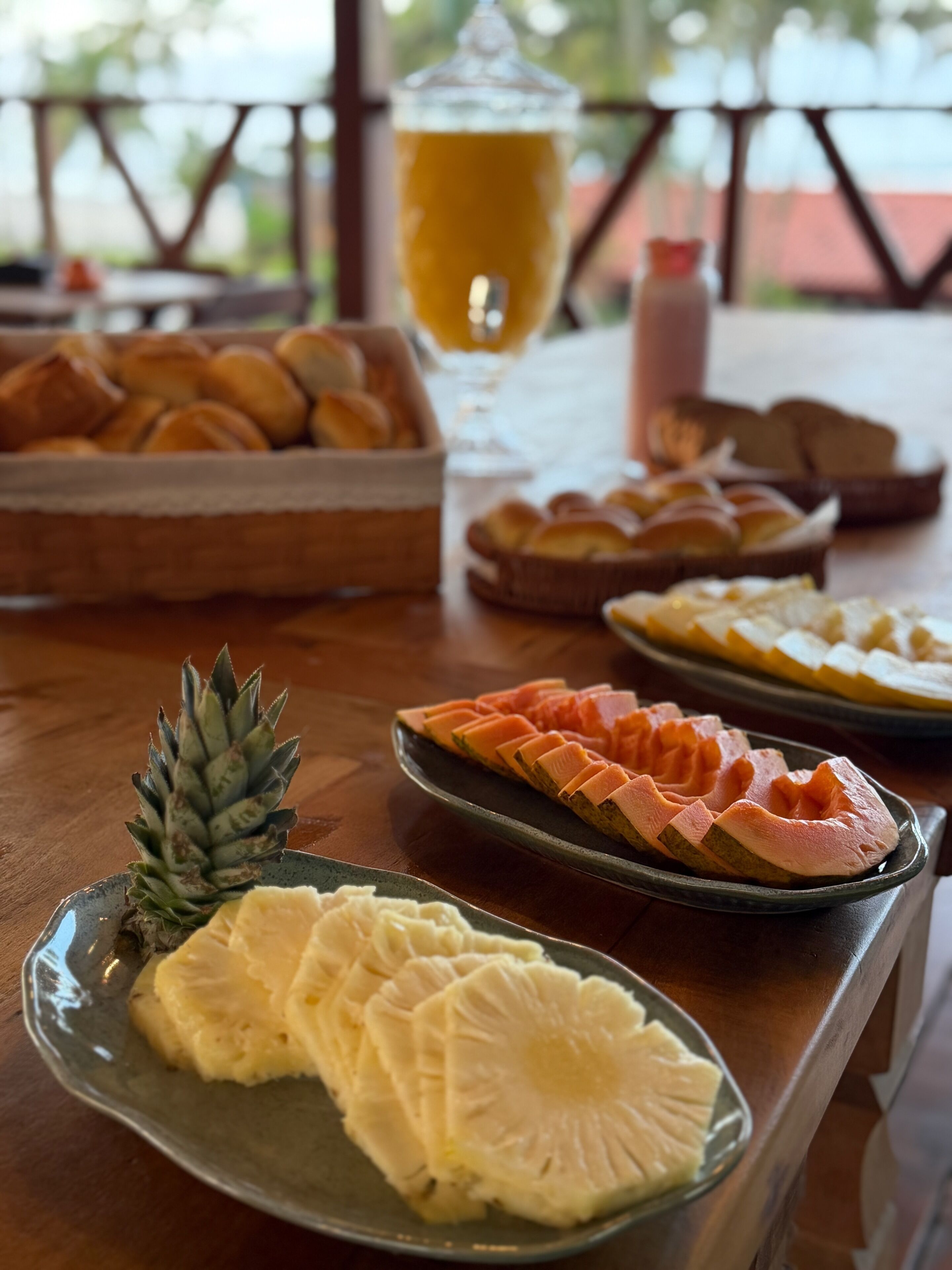 Une table à manger avec divers aliments, notamment des tranches d’ananas, du jambon et du pain.