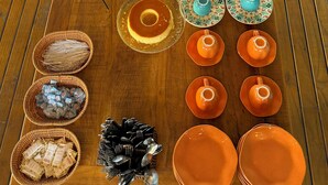 A wooden table with various desserts and pastries, tea sets, and utensils. - Santa Clara Pousada (Guarujá)