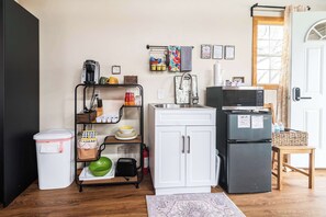 Microondas, cafetera o tetera, utensilios de cocina y mesa de comedor