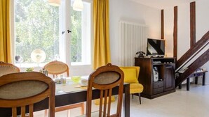 A dining area with a table, chairs, and a television in the background. - Strandvilla Hubertus - H6 - Paul Signac (Ostseebad Boltenhagen)