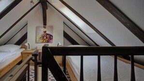 A dormitory-style room with two bunk beds, a wooden ceiling, and a painting on the wall. - Strandvilla Hubertus - H6 - Paul Signac (Ostseebad Boltenhagen)