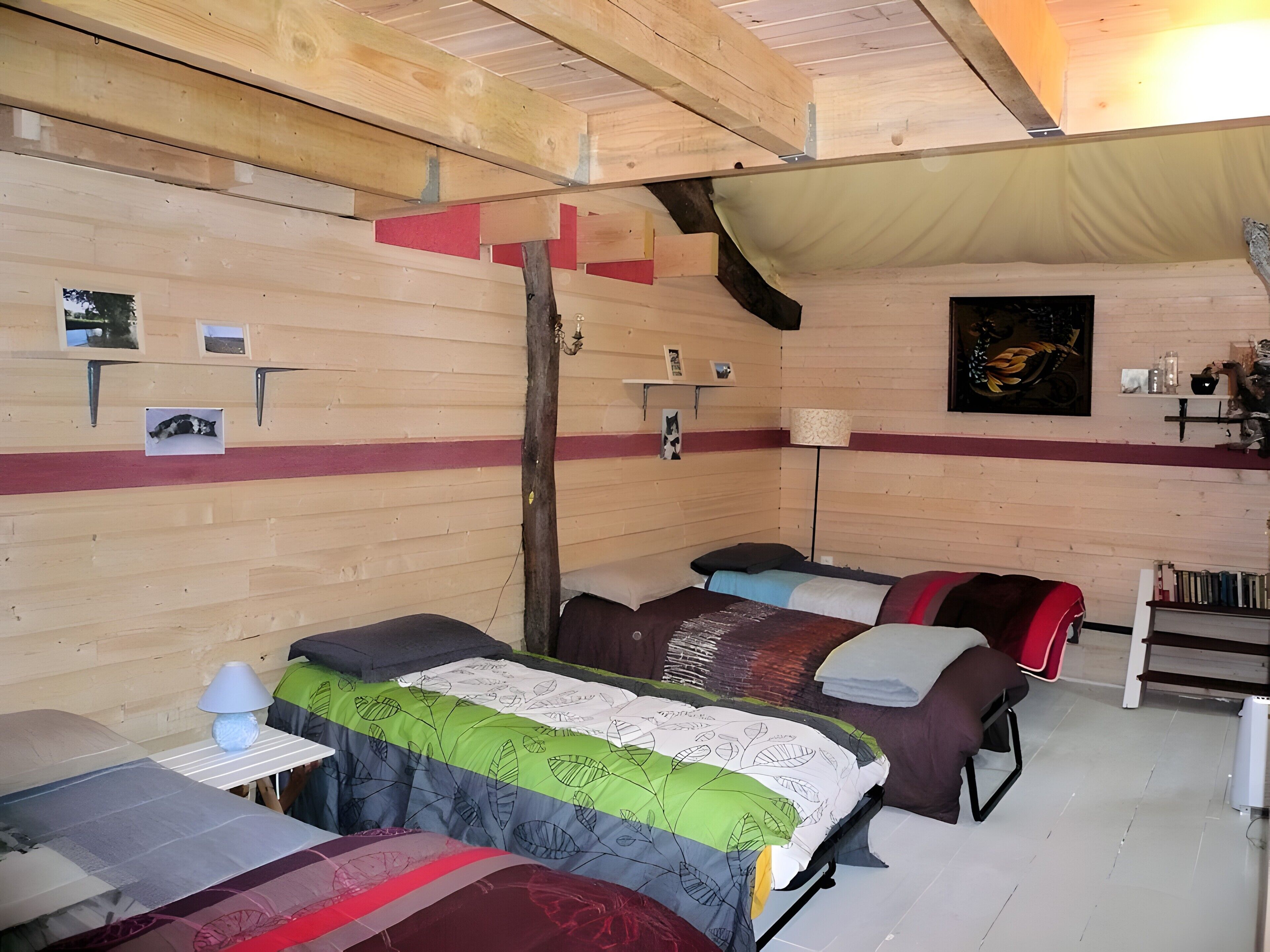 Een houten interieur met stapelbedden, een lamp en een plank met spullen.