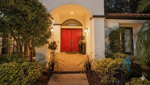 A house with a red door, an arched entrance, and a tiled pathway leading to the door. - Elegant Designer Suite: Serene Garden View & Private Entry (Escondido)