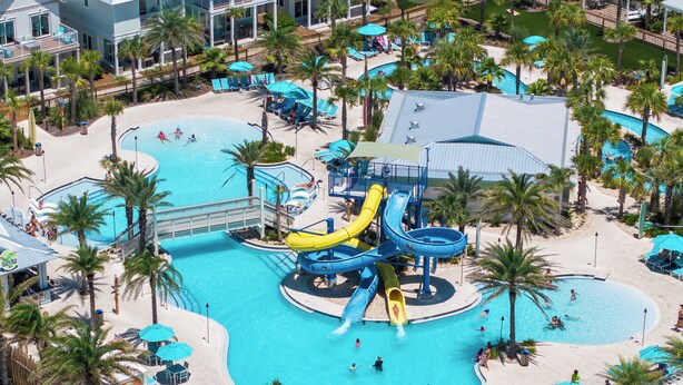 Ein Resort mit mehreren Schwimmbecken, einem Wasserpark und Palmen.