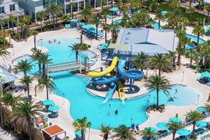 Un resort con varias piscinas, parque acuático y palmeras.