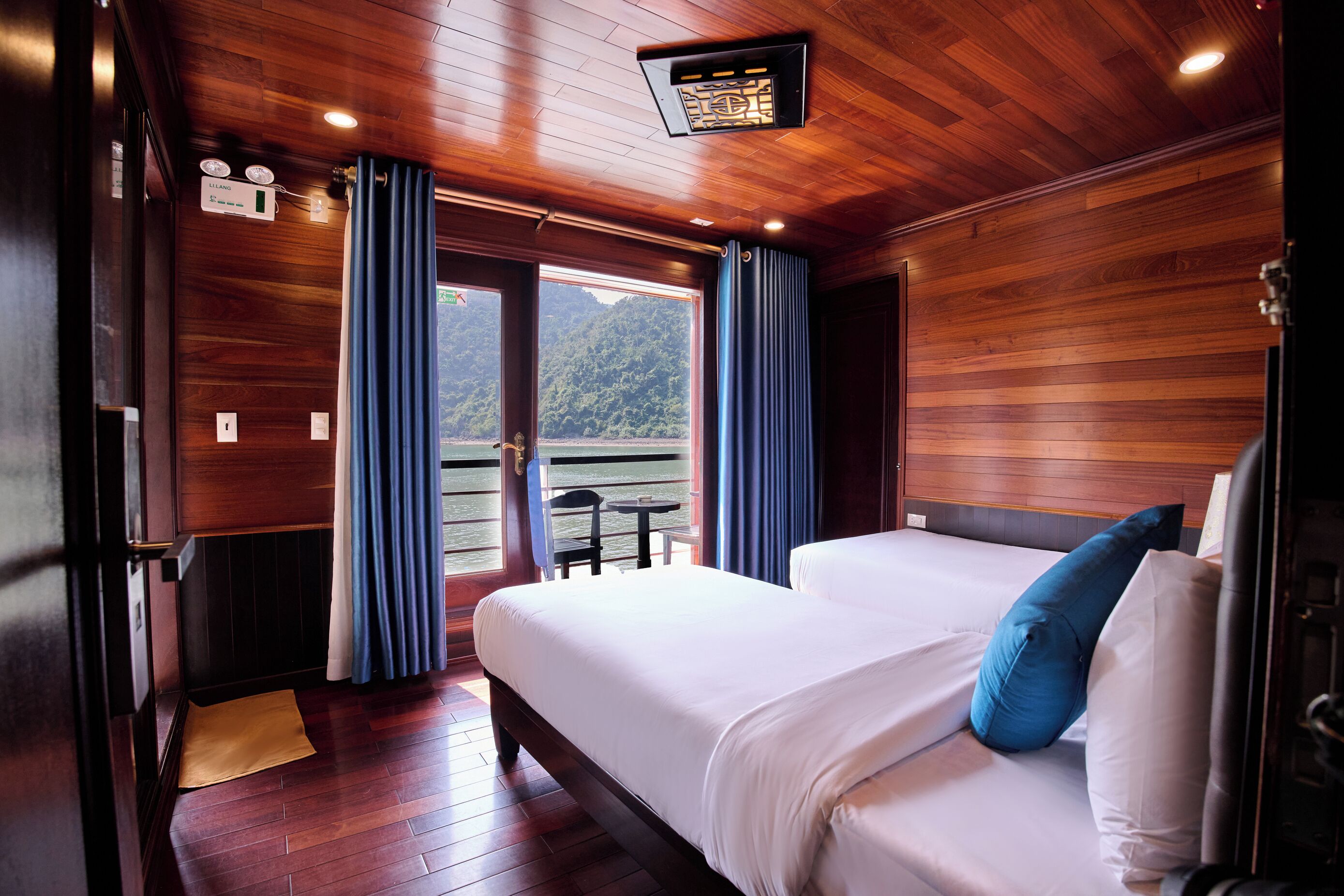 Una habitación con paneles de madera, una cama, cortinas y vistas a un balcón.