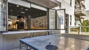 A ping pong table with a warning sign about no lifeguard on duty. - Boulevard Stays Dashing King 1 BR Suite Pool, Parking Gym M (Richardson)