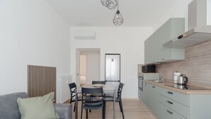 Eine moderne Küche mit Essbereich, einem grauen Sofa und einer Heizung.
