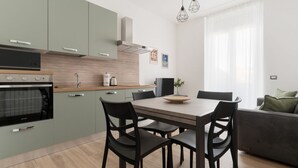 Eine moderne Küche mit Essbereich, inklusive Tisch und Stühlen, sowie eine Couch in einem hellen Wohnraum.