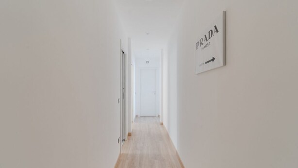 Ein Korridor mit einem Schild, das auf einen Prada-Laden hinweist.