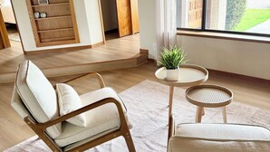 Ein modernes Wohnzimmer mit einer Couch, einem runden Tisch und einem Bücherregal mit Dekoration.