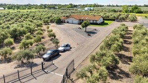Ein großer, offener Parkplatz mit zwei Autos in der Nähe eines Gebäudes mit rotem Dach.