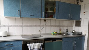 Cuina amb armaris blaus, taulell blanc, rentaplats Siemens i fogó.
