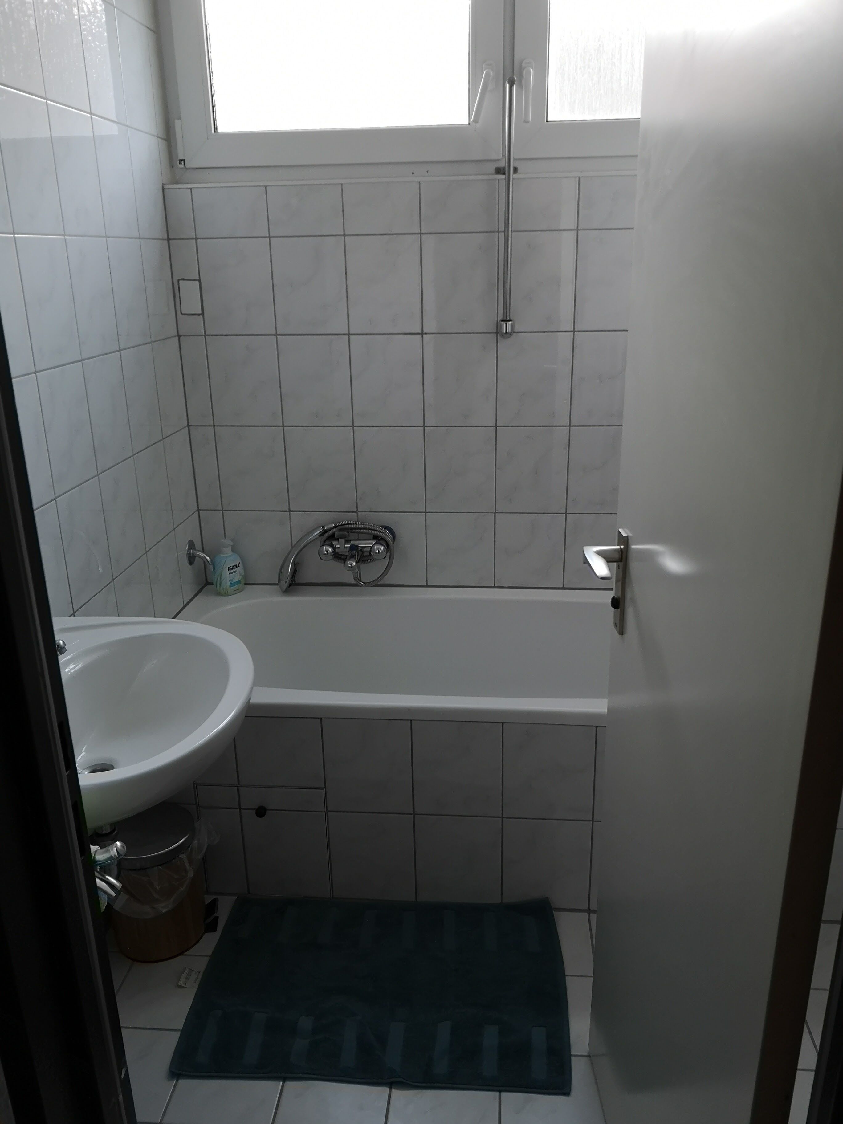 Une salle de bain avec une baignoire, un lavabo et une fenêtre.