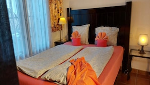 A hotel room with a bed, a nightstand with a lamp, and a window with curtains. - Detached Terrace Cottage for Adults Only (Icod de los Vinos)