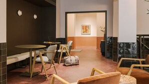 A modern lounge area with round tables, cushioned seating, and a minimalist decor. - LIVN West Loop Chicago King Studio (Chicago)