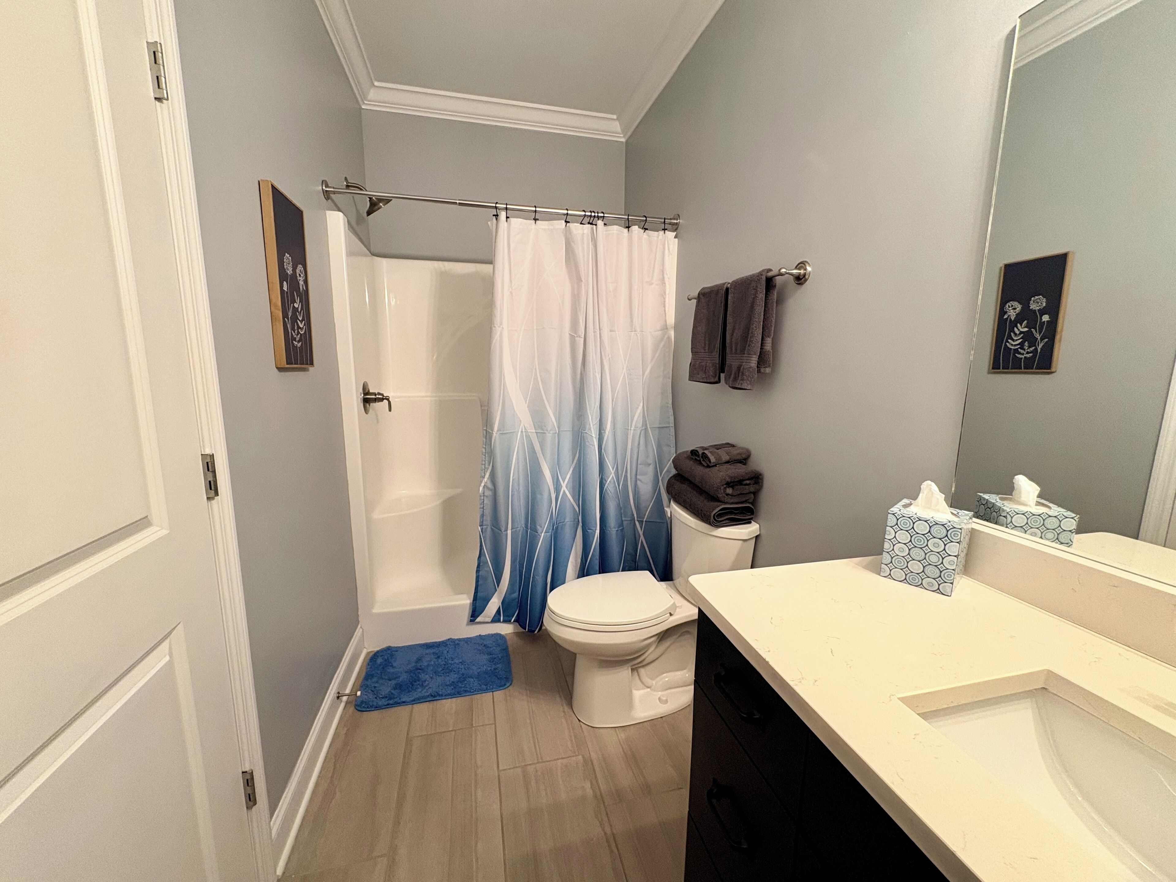 A bathroom with a shower, toilet, and sink.