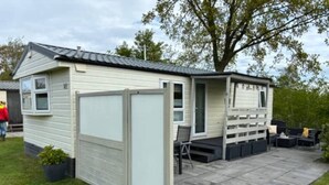 Une petite maison de plain-pied dotée d’un patio couvert.