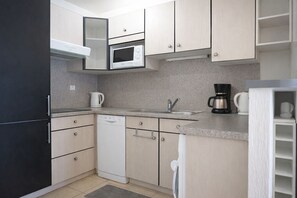 Frigorífico, microondas, cafetera o tetera y utensilios de cocina