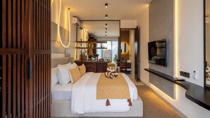 A modern hotel room with a large bed, a TV mounted on the wall, and a wooden wardrobe. - Palermo Suites by DH (Ubud)