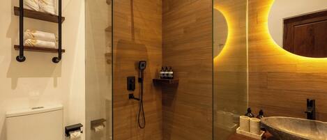 Une salle de bain moderne avec une douche à parois de verre, un lambris en bois, un grand lavabo et un porte-serviettes avec des serviettes.