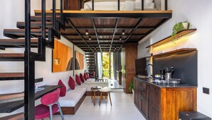A modern interior with a staircase, a kitchen area, and seating space. - Palermo Suites by DH (Ubud)