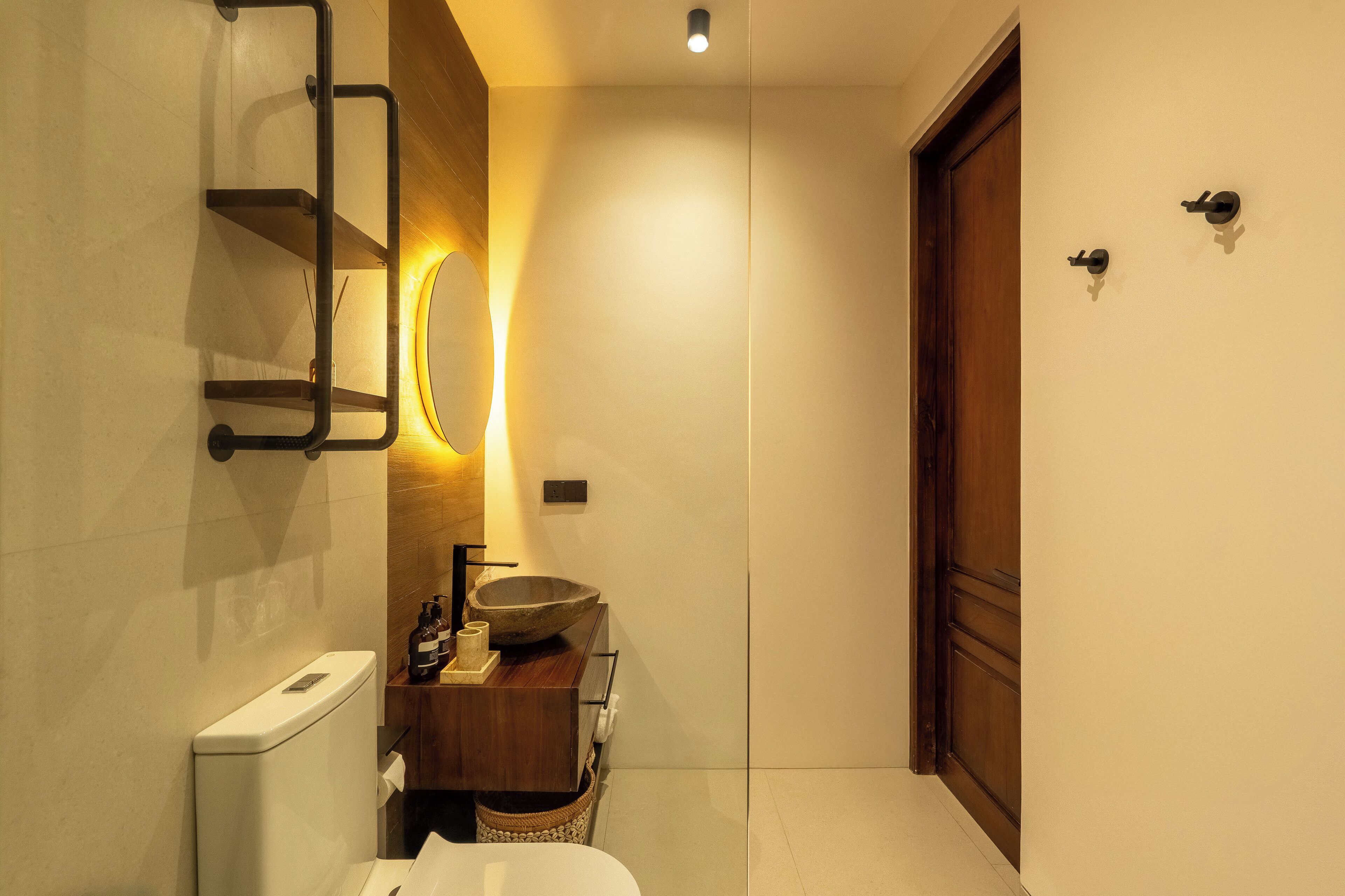 A modern bathroom with a toilet, sink, and mirror.