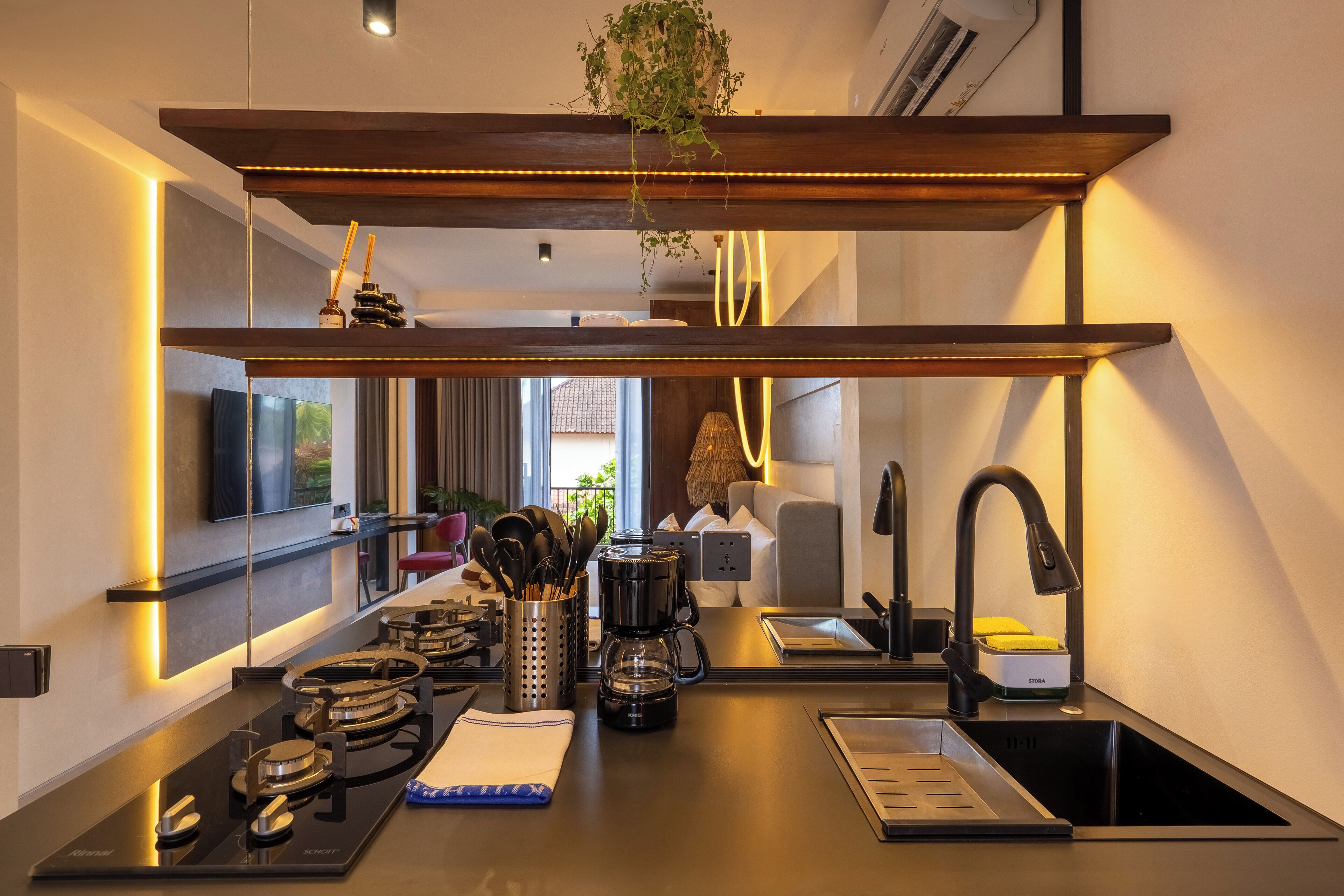 A modern kitchen with a built-in stove, coffee maker, and a sink.