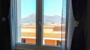 Una finestra con vista su una montagna e degli edifici.